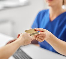 Patient handing over card to pay for dental treatment