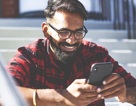 person sitting on steps and looking at their phone