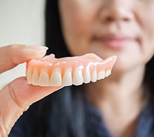 Woman holding dentures