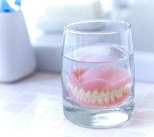 Full dentures in Azle soaking in glass