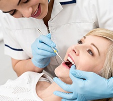Woman receiving exam from an emergency dentist
