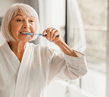 Older woman brushing her teeth