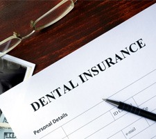 Dental insurance paperwork on wooden table