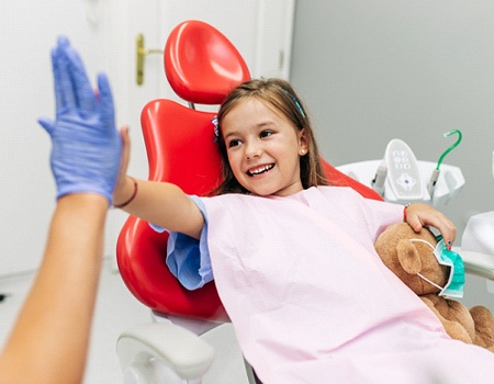Little girl high fiving a dentist after fluoride treatment