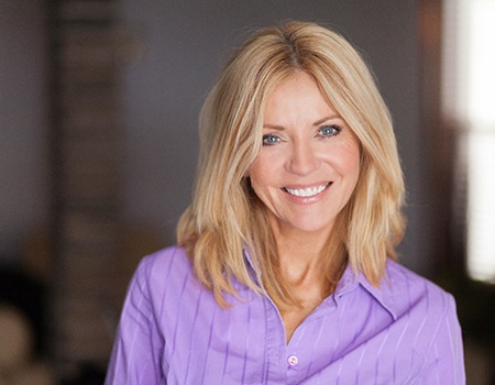 Woman in purple shirt standing and smiling