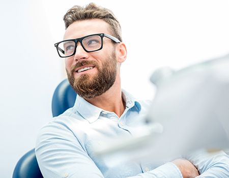 Man with dental implants in Baltimore, MD smiling in chair