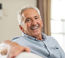 smiling elderly man sitting on a couch