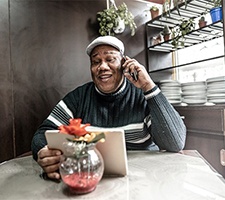 elderly man sitting at a table and talking on the phone