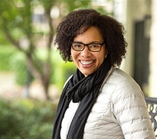 smiling woman sitting at a park bench