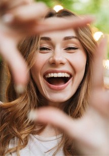 Woman forming a square around her smile with her fingers