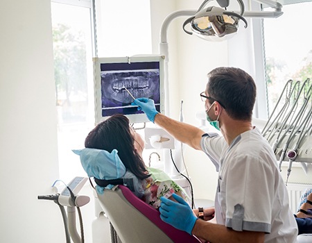 a dentist showing a patient an X-ray of their teeth