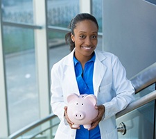 dentist holding a pink piggy bank 