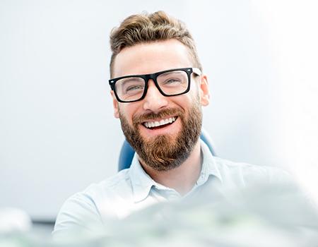 patient smiling while sitting in treatment chair 