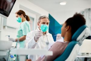 dentist talking to smiling patient 