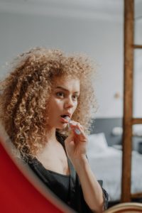 Woman looking in mirror to brush her teeth