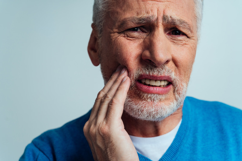 Patient wincing due to dry socket after tooth extraction