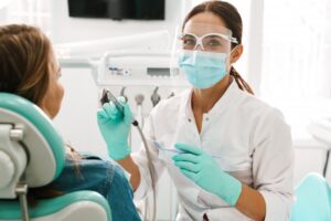 Dentist smiling and working with patient. 