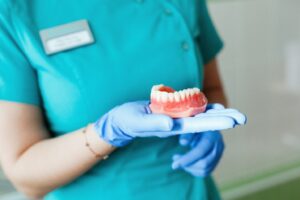 Dental staff holding pair of dentures.